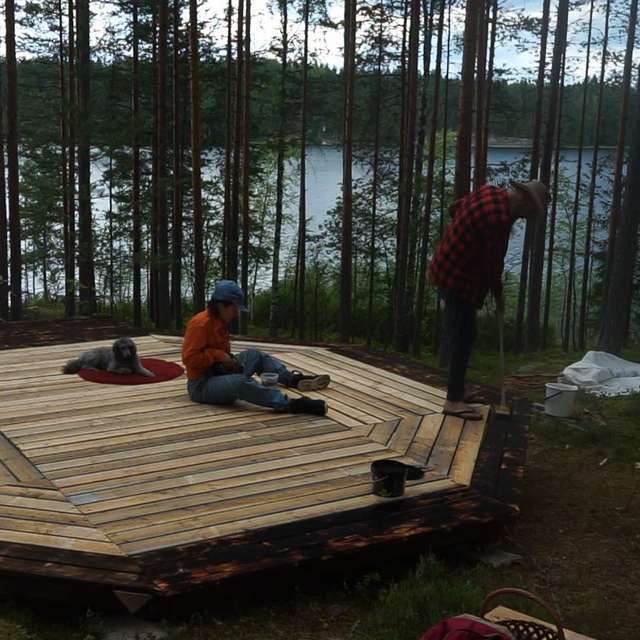 Huokoinen pari rakentaa teltan alustaa